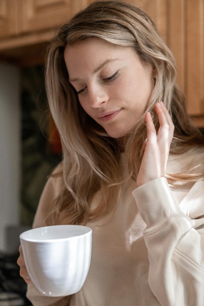 Frau blickt versonnen in ihre Teetasse